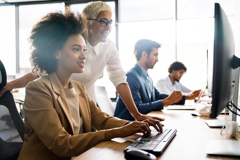 Training on the job: immagine di donna che affianca un’altra donna davanti a un computer